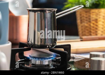 Brew coffee in a steel turk on a gas stove Stock Photo