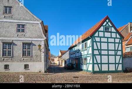 Typical fachwerk houses of old Klaipeda, Lithuania medieval town and cobbled pavement street. German style buildings of Middle Ages. Stock Photo
