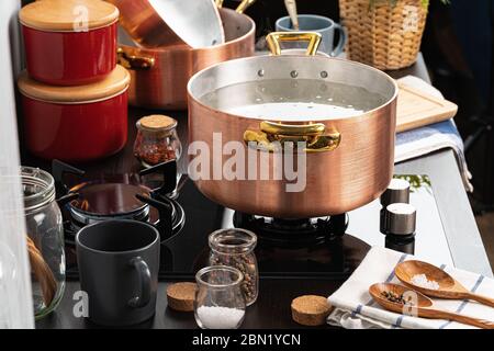 Copper pot with boiling water on a gas stove Stock Photo