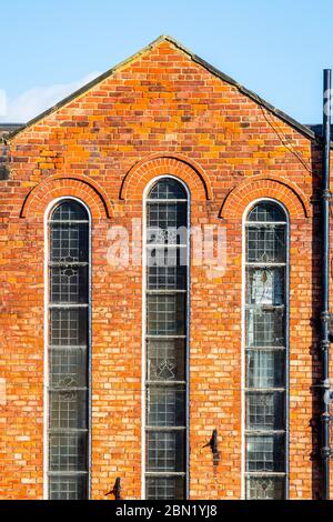 Abandoned brick building with three tall narrow windows, in Hexham, Northumberland , UK Stock Photo