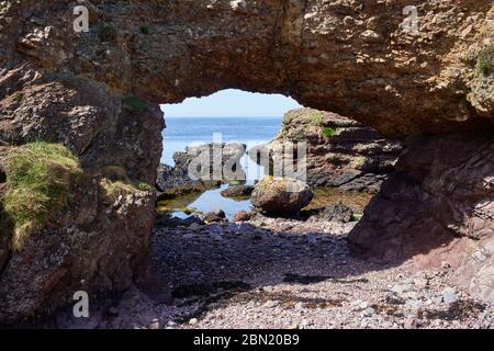 View across Castletown Bay viewed from Langness peninsular with archway made by seawater Stock Photo