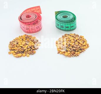 lentils and spelt with a centimeter ribbon on a white background. The concept of losing weight and fighting excess weight. Healthy diet. Stock Photo