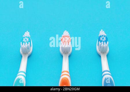 Multicolored toothbrushes on a blue background. The view from the top. The concept of dental health. Stock Photo