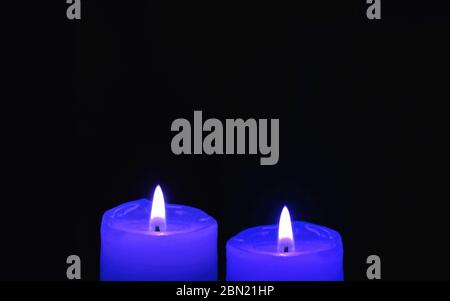 Shining Two Royal Blue Candles on Black Background with Copy Space Stock Photo
