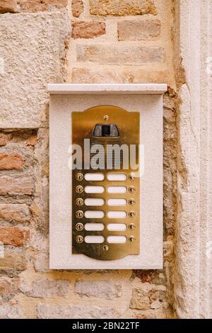 Close-ups of building facades in Venice, Italy. An old vintage intercom and a mailbox on a stone wall. On door where placed this old rusty doorbells. Stock Photo