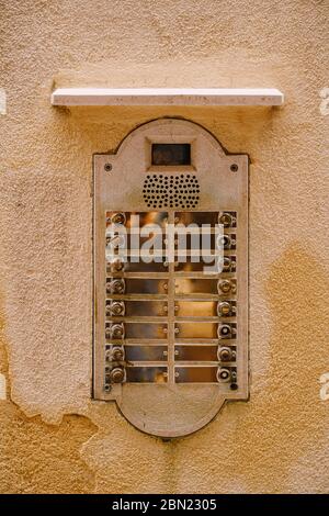 Close-ups of building facades in Venice, Italy. An old vintage intercom and a mailbox on a stone wall. On door where placed this old rusty doorbells. Stock Photo