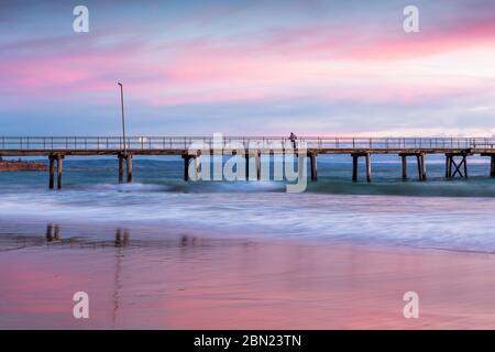 Pink hues at sunset over the jetty at port noarlunga south australia on 11th may 2020 Stock Photo