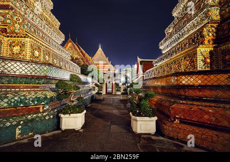 Buddhist Temple Wat Pho with golden Chedi in Bangkok at night sky in Thailand. Famous landmark and sight of the city. Stock Photo