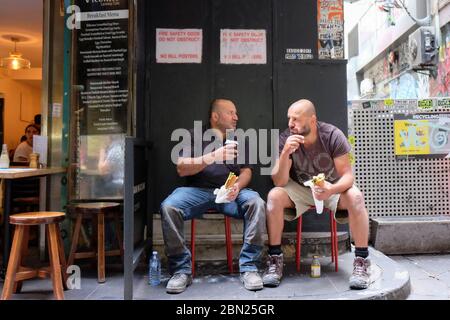 two workers having a lunch break in Degraves Lane in Melbourne,Victoria, Australia Stock Photo