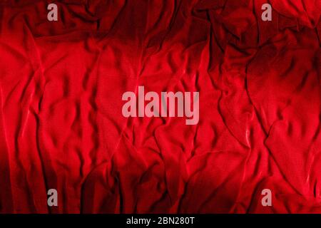 Bright red texture of binding crumpled fabric. Red textile background with natural folds. Close-up Stock Photo