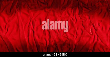 Bright red texture of binding crumpled fabric. Red textile background with natural folds. Close-up Stock Photo