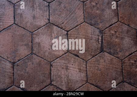 Vintage brown ceramic tile in the form of honeycombs. Hexagonal floor tiles. Stock Photo