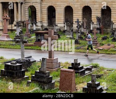 Jogger in Brompton Cemetery, Old Brompton Road, Kensington, London; one of the Magnificent Seven cemeteries Stock Photo