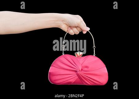 hand holding red luxury clutch bag isolated on black background. Stock Photo