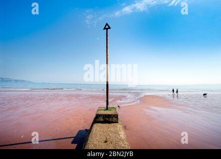 A groyne marker on the near deserted beach at Paignton during the Coronavirus lockdown, UK Stock Photo