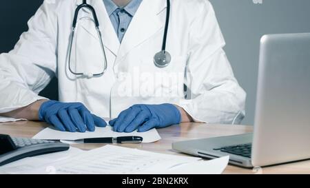 Doctor looking at medical files working with coputer Stock Photo