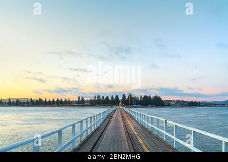 Sunset over Victor Harbor beach viewed from Granite Island jetty at Encounter Bay, South Australia Stock Photo