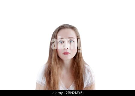 Sad young caucasian woman with unhappy facial expression, isolated on white background, close-up portrait, looking at camera Stock Photo