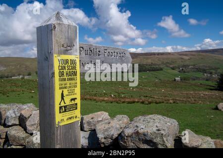 Sign on a Public Footpath signpost, warning against allowing dogs of their leads around livestock. Yorkshire Dales National Park, UK. Stock Photo