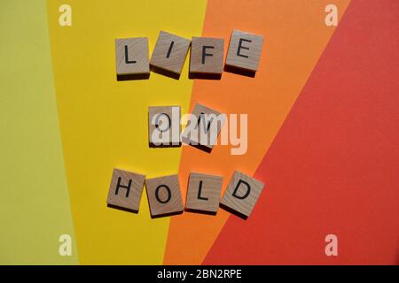 Life on Hold, words in 3d wooden alphabet letters isolated on colourful background Stock Photo