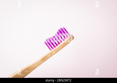 Pink fuchsia bamboo toothbrush on a light background. Eco friendly concept. Copy space Stock Photo