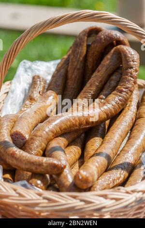 Traditional Romanian fresh smoked sausages for sale in a wooden basket Stock Photo