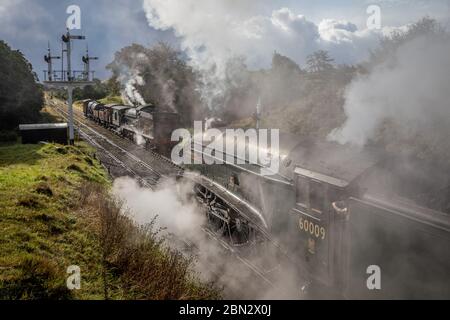 LNER 'A4' 4-6-2 No. 60009 'Union of South Africa' passes NE 'Q6' 0-8-0 No. 2238 as it departs Goathland on the North Yorkshire Moors Railway Stock Photo