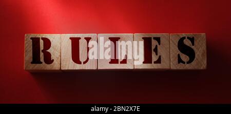 Rules word on wooden cubes on red background. Rules, policies and procedures law concept Stock Photo