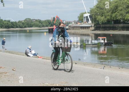 Putney London, UK. 12 May 2020. Coronavirus Lockdown. People enjoying the warm weather on Putney embankment  South West London as the Government is set to relax the law on lockdown on (Wednesday 13 May 2020) to allow the public to  spend more time outdoors and enjoy the picnics, sunbathing  while following social distancing guidelines. Credit: amer ghazzal/Alamy Live News Stock Photo