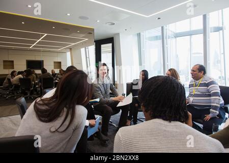 Business people discussing paperwork in circle in meeting Stock Photo