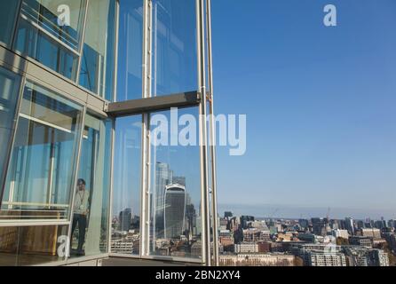 Businessman using smart phone at sunny highrise office window Stock Photo