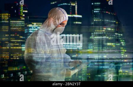 Male scientist in clean suit using digital tablet and working late