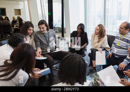 Business people talking in circle in conference room meeting Stock Photo