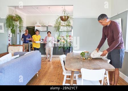 Mature couples setting dining table for lunch Stock Photo