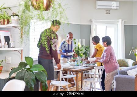 Mature couples setting dining table for lunch Stock Photo