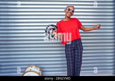 Portrait happy young female musician with tambourine Stock Photo