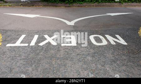 No Exit painted white onto the road and viewed upside down with a split arrow indicating alternative directions Stock Photo