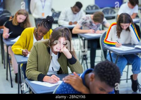 High school girl student taking exam at desk in classroom Stock Photo