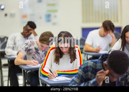 Focused high school girl student taking exam at desk in computer Stock Photo