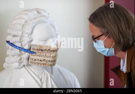 12 May 2020, Saxony, Leipzig: A woman tries to read the text of the cantata 'Mein Herze schwimmt im Blut' (My heart swims in blood), from whose notes a mouthpiece for a Bach bust was found in the Bach archive before the exhibition 'Bach and Beethoven. True art remains eternal' was made. Actually, the show was supposed to start on March 26, but then Corona threw the plans overboard. According to the director of the Bach Archive, the basic idea was to show how the middle-class music public in Leipzig in the early 19th century was prepared to appreciate Beethoven's harsh and difficult to Stock Photo