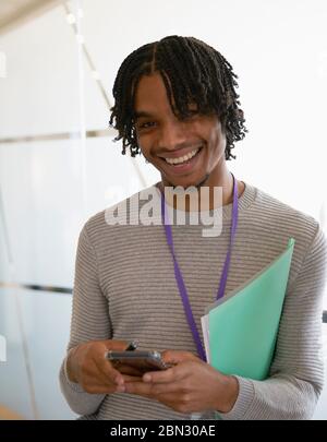 Portrait happy businessman texting with smart phone in office Stock Photo
