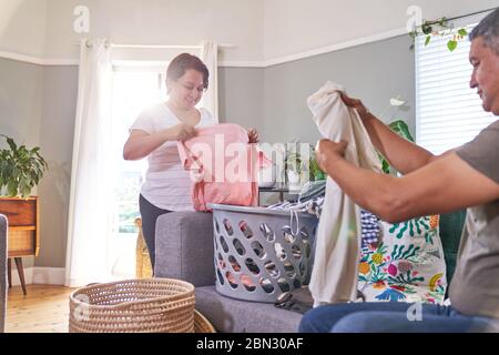 Mature couple folding laundry in living room Stock Photo