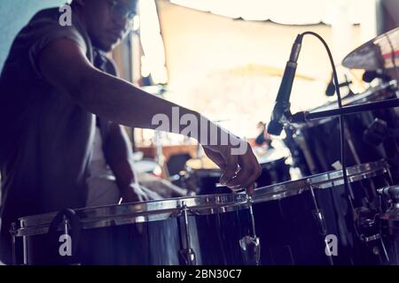 Male drummer adjusting drums in recording studio Stock Photo