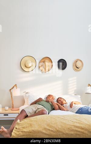 Happy affectionate couple relaxing on bed Stock Photo