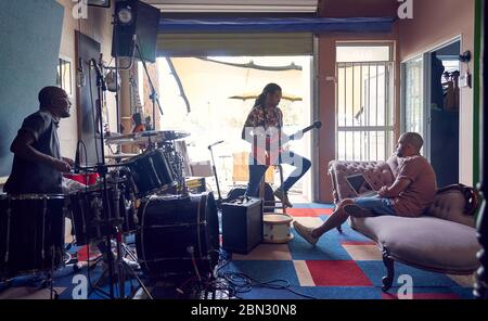 Male musicians practicing in garage recording studio Stock Photo