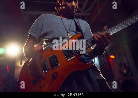 Male musician playing electric guitar on stage Stock Photo