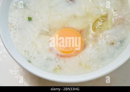 Rice porridge with pork topping egg yolk on bowl Stock Photo