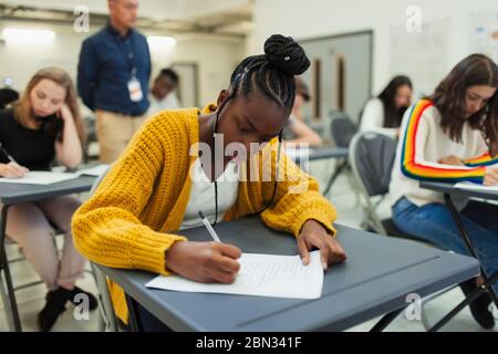 Focused high school girl student taking exam at desk Stock Photo