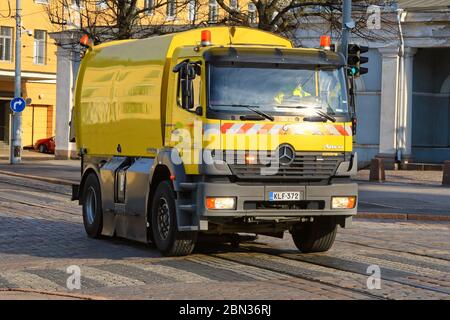 Yellow Mercedes-Benz Atego 1828 mounted Shorling street sweeper cleans street on a day of spring in Katajanokka, Helsinki, Finland. May 6, 2020. Stock Photo