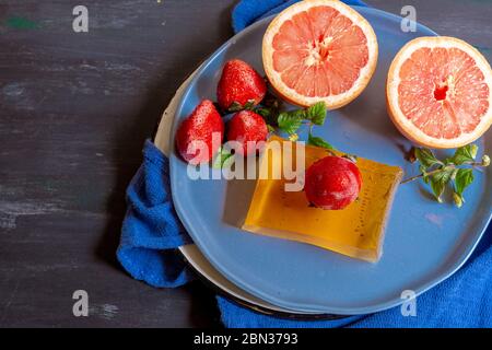Grapefruits on blue background and decorated plate, to make juices or to enjoy in an afternoon at home Stock Photo